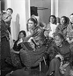 Inuit musician Annie Johannes playing accordian at a dance at the Department of Resources and Welfare school July 1951
