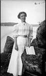 Unidentified woman standing near rocks ca. 1907
