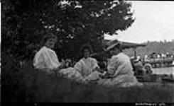 Three unidentified women relaxing on lawn, Muskoka Lakes ca. 1910