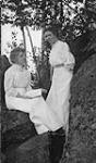 Two unidentified women sitting on rocks ca. 1907
