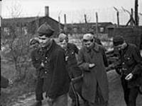 Russian inmates pulling sanitation wagon in German prisoner-of-war camp liberated by the 4th Canadian Armoured Division 12 Apr. 1945