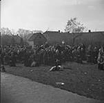 Civilians gathered in churchyard during fighting between German paratroopers and personnel of the 4th Canadian Armoured Division 10 Apr. 1945