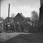Civilians entering churchyard for interrogation by personnel of the 4th Canadian Armoured Division about German troop movements 10 Apr. 1945