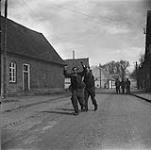 4th Canadian Armoured Division's drive towards Oldenburg. After fall of Sogel, German prisoner is escorted to P.O.W. cage 10 Apr. 1945