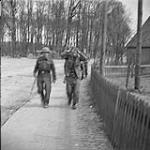 4th Canadian Armoured Division's drive towards Oldenburg. After fall of Sogel, German prisoner is escorted to P.O.W. cage 10 Apr. 1945