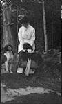 Unidentified women dressing up dogs, Trinity Point, Muskoka Lakes ca. 1908