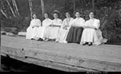 Unidentified group of women sitting on log, Royal Muskoka Hotel, Rosseau Lake, Muskoka Lakes ca. 1908
