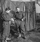 Privates Art Irvine and Mike Peden, both of "D" Company, The South Saskatchewan Regiment, verifying the quality of a parachute Mook, Netherlands, 30 November 1944 November 30, 1944.