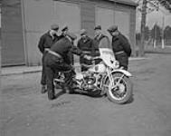 Canadian Officers Training Corps at Canadian Provost Corps School. Officer Cadets receive motorcycle training. L. to r.: J.R. Waterton, W.P. Stoker, C.A. Walker, A.G. Ward and the instructor 21 May 1950