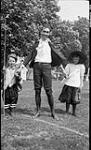 Unidentified man with two children at the Dominion Council Y.W.C.A., College Day, Elgin House, Muskoka Lakes 1 July 1909