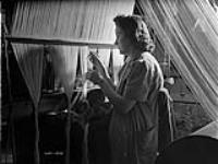 Hélène Lalonde, ouvrière à la manufacture de textiles de la Montreal Cottons, travaille sur un métier à tisser ca. Mar. 1942