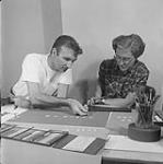 Evelyn Lambart and Norman McLaren of the National Film Board working on Rhythmetic, a film in which cut-outs of numbers wereanimated June 1956
