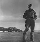 Unidentified member of the U.S.A.A.F. in front of line of Boeing B-17 aircraft en route to Britain May 1943