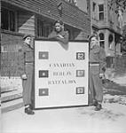 CANADIANS IN GERMANY. Regiment representatives in the Berlin Battalion in front of headquarters. L. to r.: Fusilier Léopold Desfossés (Fusiliers Mont-Royal), Pte. Bob Jane (Argyll & SutherlandHighlanders), and Pte. Max DeForest (Loyal Edmonton) 16-Jul-45
