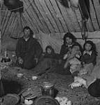 Although the traditional home fo the Eskimo is the snow-built igloo, natives of the more southerly regions live in log-walled tents of log-and-mud huts like this one Jan. 1946