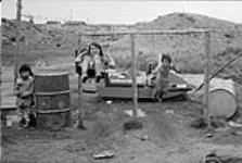 Cree children playing on swings 1973
