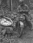 Driver Arnold Burtch checks his watch 3 Apr. 1945