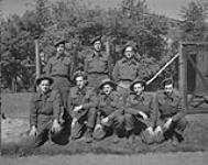 Members of the 48th Highlanders of Canada. Front row, left to right: Cpl. Earl Crawford, Pte. T. Grignon, Pte. E. Gartland, Pte. John Hardy, L/Cpl. A. Quitor, Pte. Cecil Carter, Pte. Percy Carlyle 19 Apr. 1945