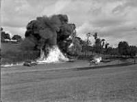 Queen's Own Rifles demonstrate flame throwers in action against dugouts among the trees 29-Jul-44