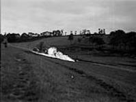 Queen's Own Rifles demonstrate flame throwers in action against dugouts amongst the trees 29-Jul-44