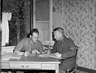 Private Robert Sawyer and Corporal Arnold Hall writing wrappers in the circulation of room for the "Maple Leaf" newspaper 28-Jul-44