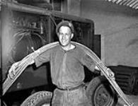 Sapper Fred Hudson with electrical cable connecting generator to the press used to print the first issue of THE MAPLE LEAF 28-Jul-44