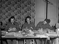 Personnel in the news room of THE MAPLE LEAF. (L-R): Corporals Bill Miller, George Kidd, Al Vickery 28-Jul-44
