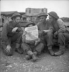 Soldiers reading first issue of the Maple Leaf in their lines. L. to r.: Ptes. Erwin Campbell, Bill Smith, Murray Shapiro and Max Stockman 28-Jul-44