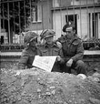 Personnel of the Calgary Highlanders reading the first issue of the Maple Leaf newspaper , Caen, France, 28 July 1944 July 28, 1944.