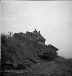 Tank of the Canadian Armoured Regiment climbs over rough ground July 1944