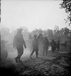 Infantry of the Stormont Dundas and Glengarry Highlanders crossing Orne River on Bailey bridge erected by Royal CanadianEngineers 18-Jul-44