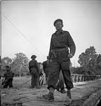 Brigadier D.G. Cunningham, Commander of the 9th Canadian Infantry Brigade, crossing the Orne River on a Bailey bridge built by the Royal Canadian Engineers (R.C.E.) en route to Caen, France, 18 July 1944 July 18, 1944.