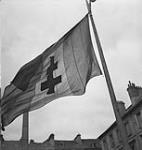 French flag (with cross of Lorraine) flies again in the City Square 11 July. 1944