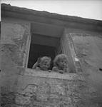 Two children waving to soldiers 10 July. 1944
