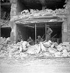 Infantrymen of The Regina Rifle Regiment inside a damaged building, Caen, France, 10 July 1944 July 10, 1944.