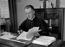 Mgr. Olivier Maurault, Rector of University of Montreal, at his desk 26 Apr. 1947