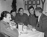 Queen's Own Rifles of Canada Christmas dinner, including, L-R:Rfmn W.D. Sanders, C.A. Morasse, A. W. Newman, with Mr. Gordon Graydon, Progressive Conservative Member of Parliament 25 Dec. 1945