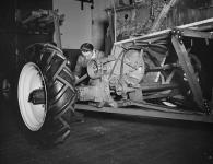 Un travailleur de l'usine de la société Massey Harris Limited termine le châssis d'une moissonneuse-batteuse July 1945