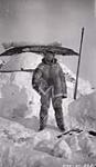 Dr. L.D. Livingston standing in front of igloo 1927