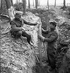 Private R. Neel and Sergeant R.B. Swain of The Queen's Own Cameron Highlanders of Canada examining a German bazooka anti-tank weapon found in an abandoned trench in Hochwald, Germany, 5 March 1945 Marh 5, 1945.