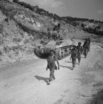 Personnel of Princess Patricia's Canadian Light Infantry advancing past a 'Sherman' tank 19 July 1943