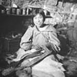 [Inuit Elise Qulaut (born Kutikutuk) making a belt. Igloolik, N.W.T., 1953.] 1953