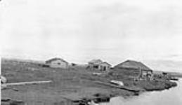 À gauche, résidence pour filles, école de la mission de l'Église anglicane - au centre, ancien magasin de la Baie d'Hudson - à droite, vieil entrepôt. Shingle Point, District de Mackenzie, Yukon, 1930 1930