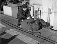 Electrical personnel adjusting the ceasefire circuit of the port anti-aircraft guns of H.M.S. NABOB, Vancouver, British Columbia, Canada, 27 January 1944 January 27, 1944.