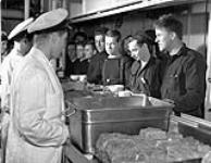 Naval ratings lining up for dinner in the cafeteria of the Canadian-manned aircraft carrier H.M.S. NABOB, Vancouver, British Columbia, Canada, January 1944 January 1944.