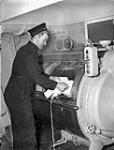 Stoker First Class L.H. Swallow in the laundry compartment of H.M.S. NABOB, Vancouver, British Columbia, Canada, January 1944 January, 1944.