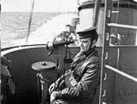 Unidentified sailor on watch aboard H.M.C.S. IROQUOIS at sea, 1943 1943