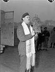 H/Captain Samuel Cass, a rabbi, conducting the first worship service celebrated on German territory by Jewish personnel of the 1st Canadian Army near Cleve, Germany, 18 March 1945 Marh 18, 1945.