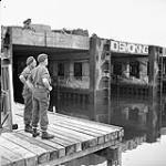 Sergeant Pat Wood and Lieutenant L.F. Labow of the 2nd Drilling Company, Royal Canadian Engineers (R.C.E.), preparing the demolition of former German E-Boat pens, Ostend, Belgium, 21 May 1945 May 21, 1945