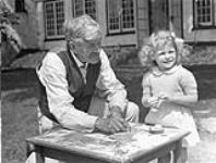 Stephen Leacock with his three-year-old grand-niece and god-daughter Nancy Nimmo at Leacock's home in Old Brewery Bay ca. 18 August 1941